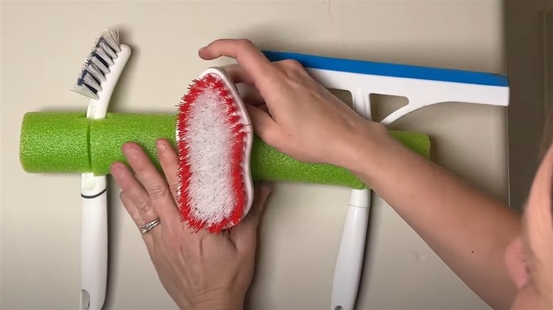 Using a pool noodle to clean cleaning supplies