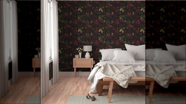 Dark floral wallpaper covers a bedroom wall