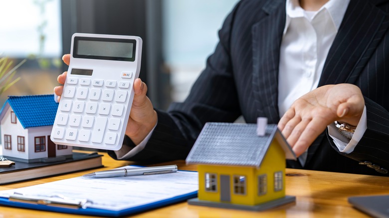 Real estate professional holding calculator