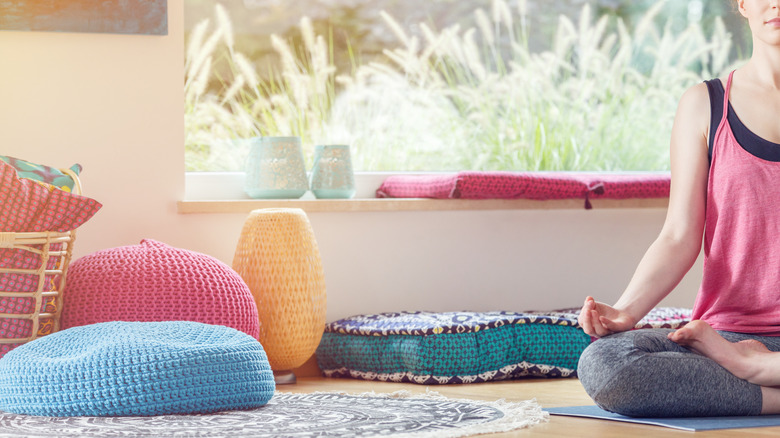 Floor cushions and woman meditating