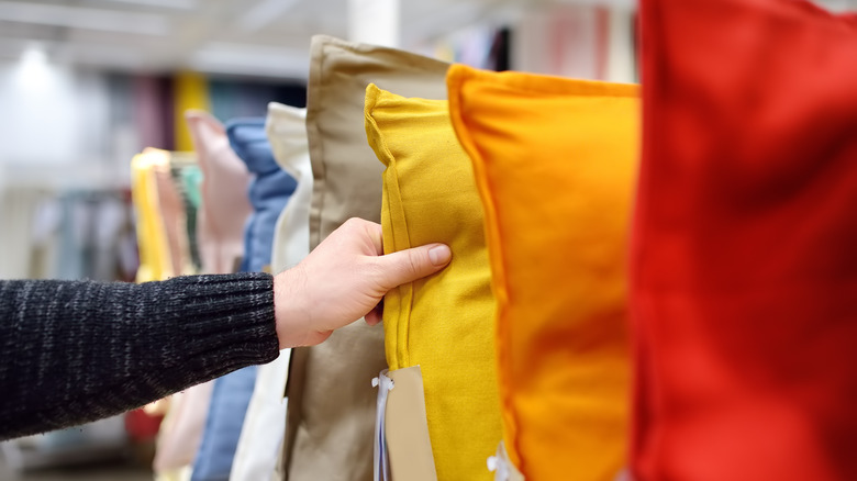 Hand reaching for yellow pillow