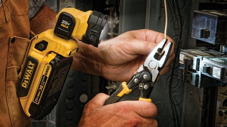 An electrician uses a DeWalt clip on light to illuminate his pliers and wire