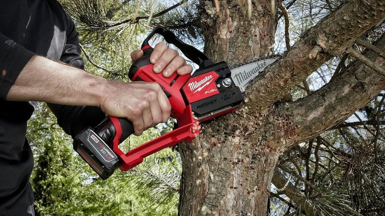 Man using Milwaukee mini chain saw