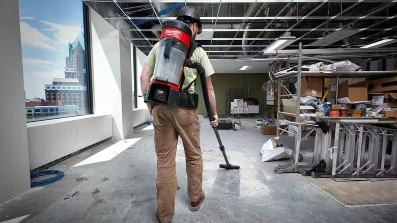 Man cleaning construction site with Milwaukee Backpack Vacuum