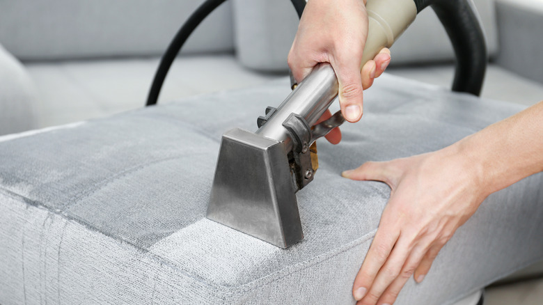 Vacuuming couch with handheld hose 