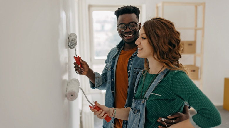 A young couple painting a wall