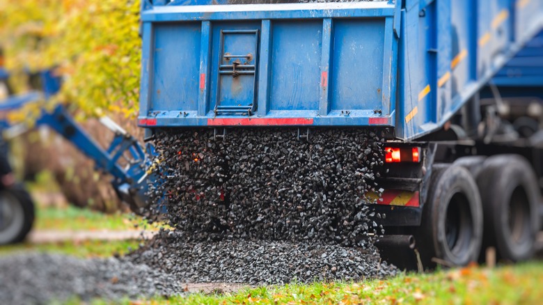 Truck dumping gravel on a driveway