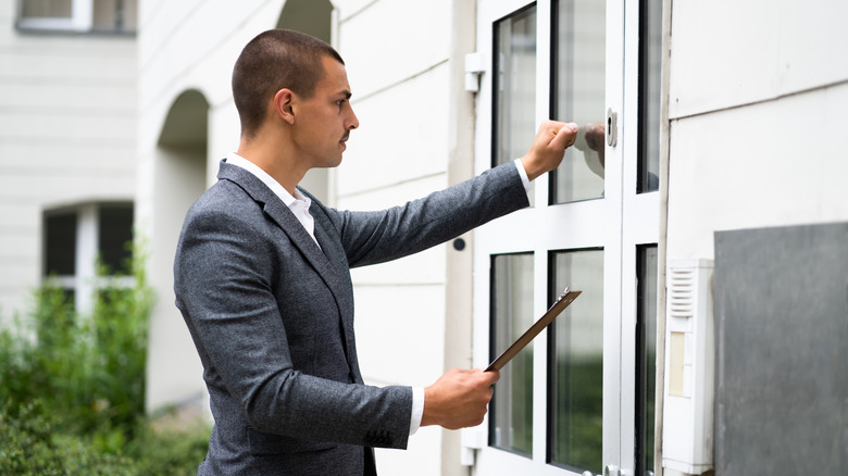 suited man knocking on door