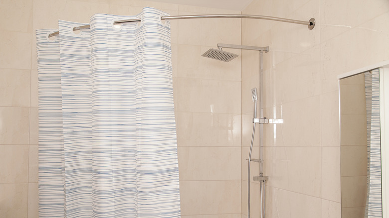 Modern corner shower with a curved curtain rod and a stripey curtain