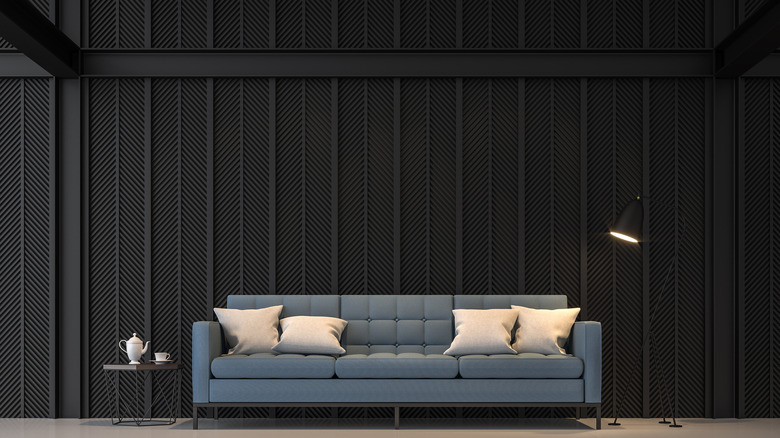 Blue couch against a black wall