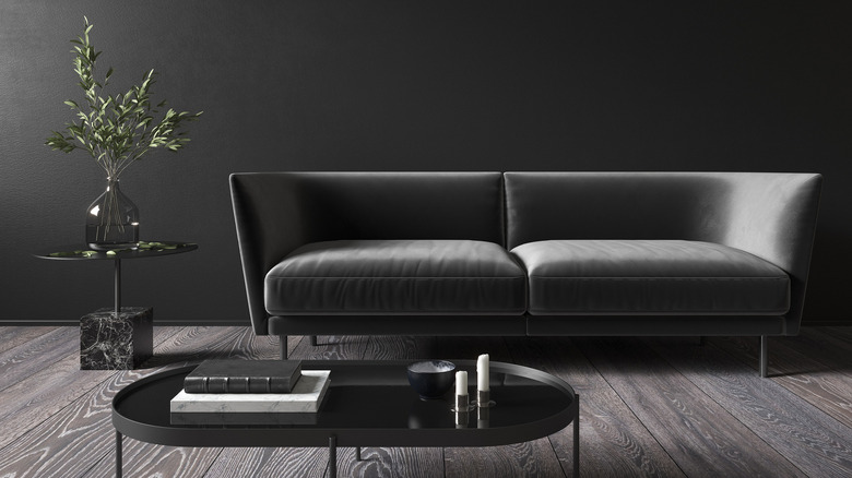 Dark gray couch, black wall