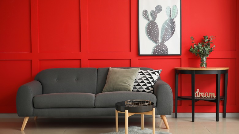 red wall behind gray couch