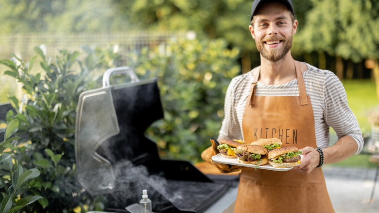 man barbecuing in backyard