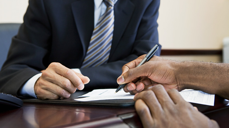 man signing paperwork