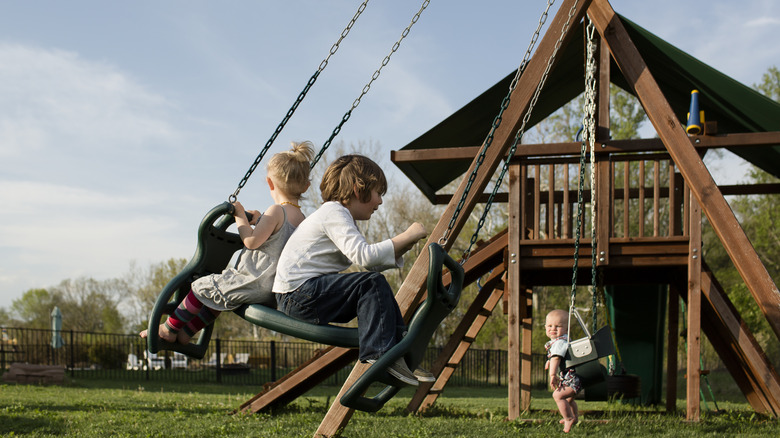 Children playing on a wooden outdoor play set