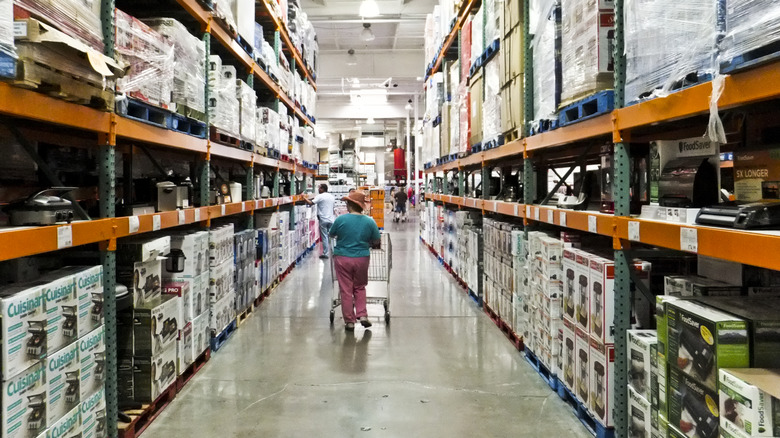 Woman rolling a cart thorough the aisles of Costco