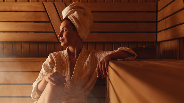 Woman sitting in wooden sauna