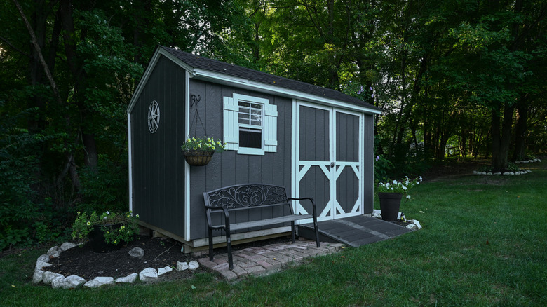 Gray backyard shed with white detailing