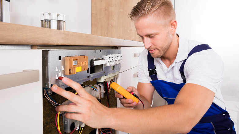 technician repairing dishwasher