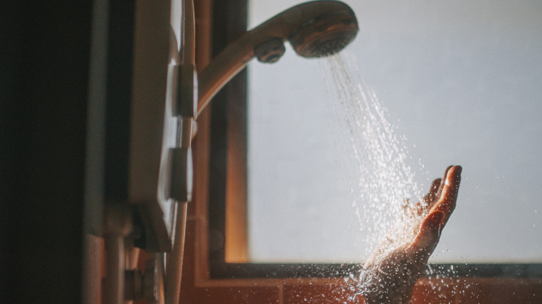 Shower head with water spraying on a hand