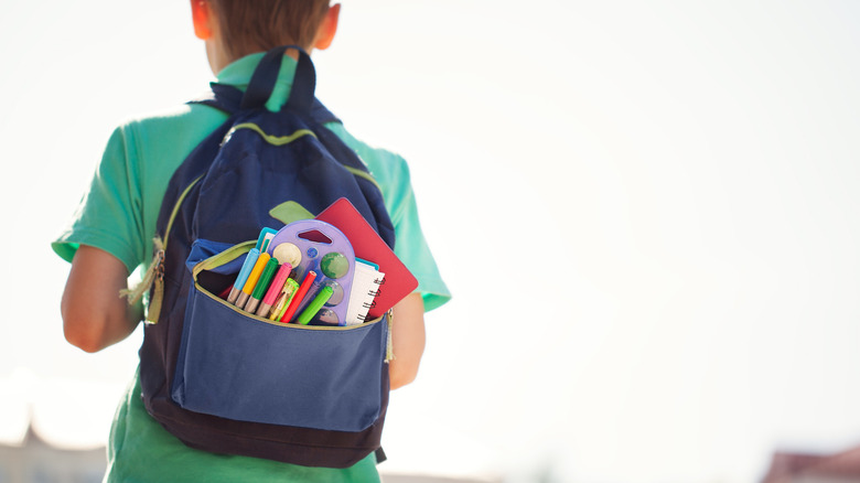 Boy walking away with backpack