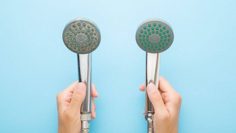 hand holding two showerheads