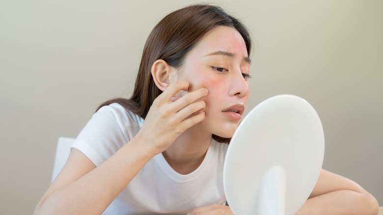 woman looking at her skin