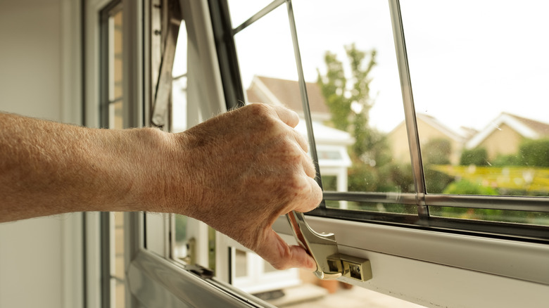 Person closing a window