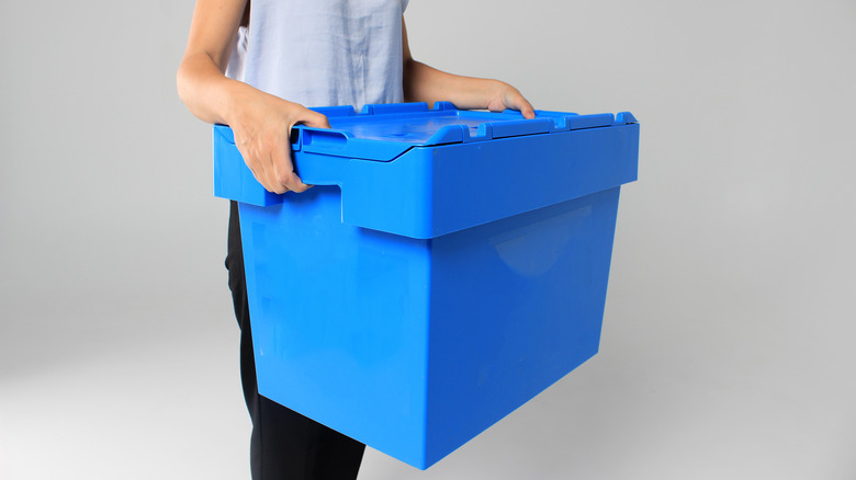 woman holding blue storage bin