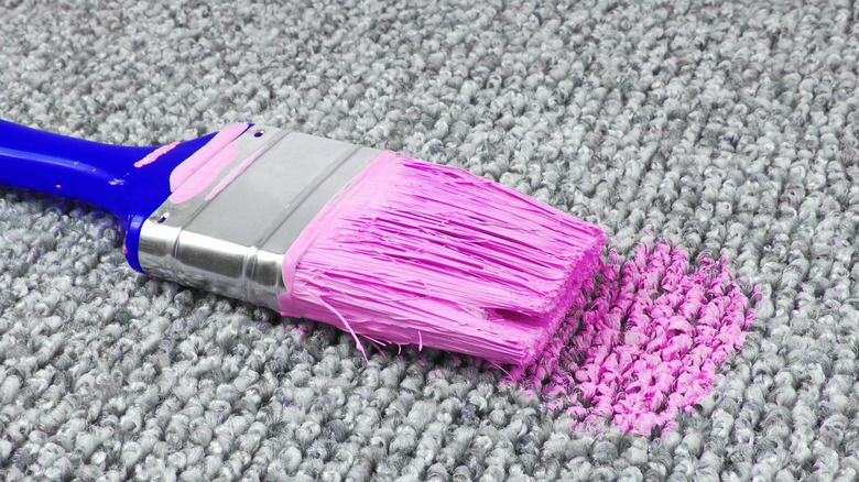 Brush with paint on carpet