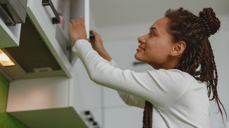 Woman opening cabinet