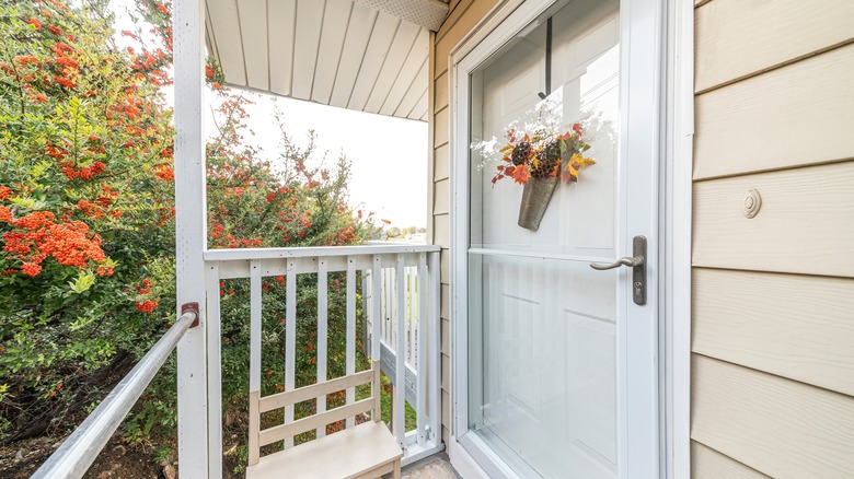 White storm door yellow siding