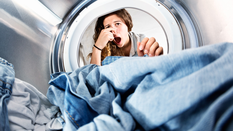 Person smelling bad scent from dryer