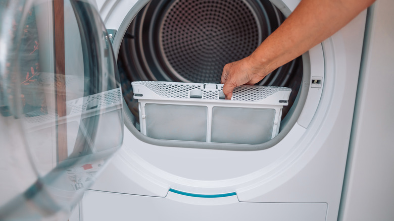 Person pulling lint tray out