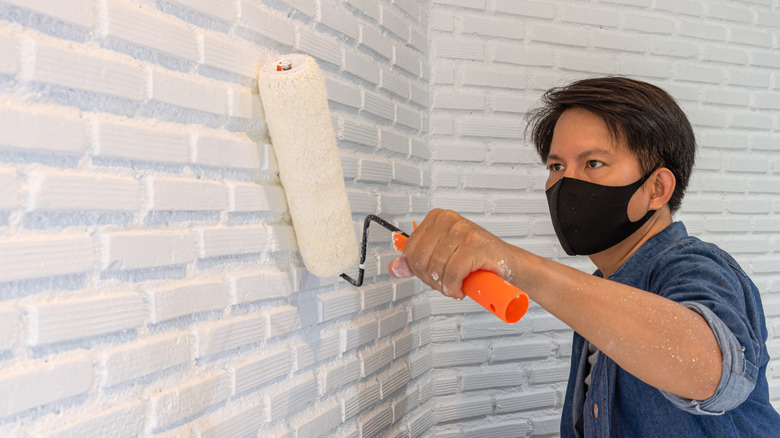 man painting brick wall