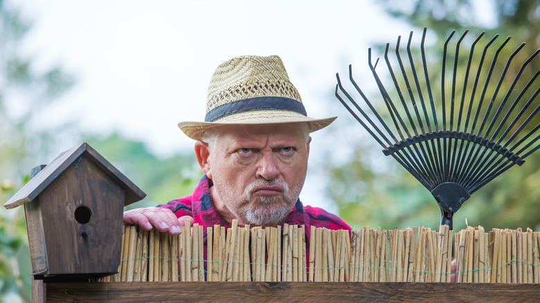 angry man looking over fence