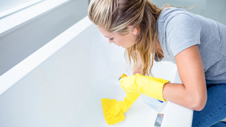 Woman cleaning bathtub