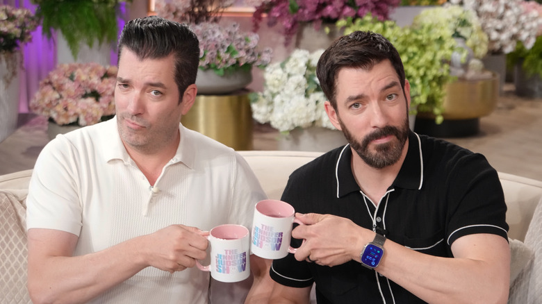 Drew and Jonathan Scott toasting with mugs