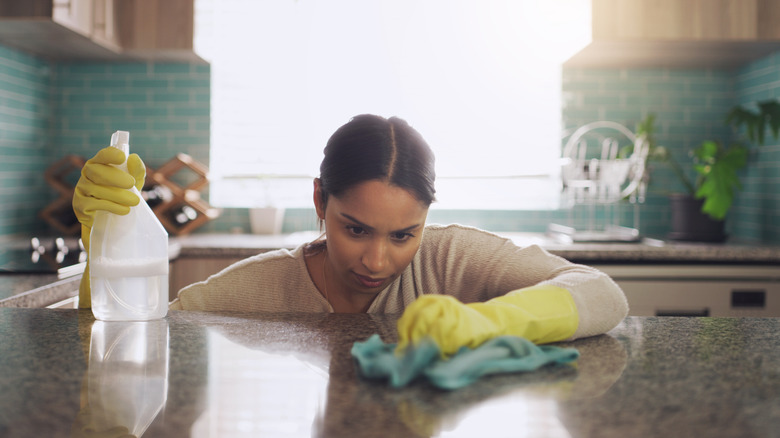 A person inspecting and cleaning polished granite countertops