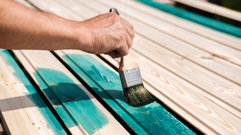 A deck being painted turquoise