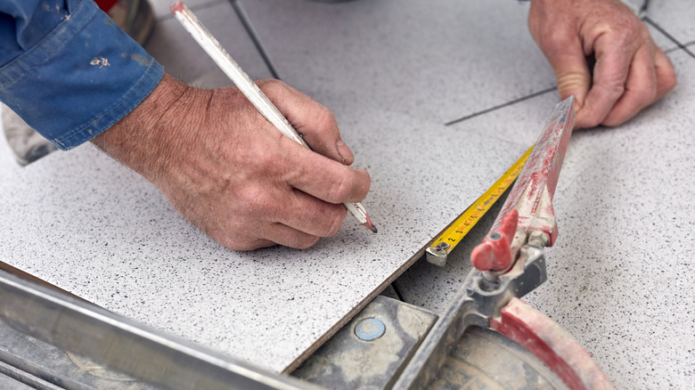 Person measuring tiles