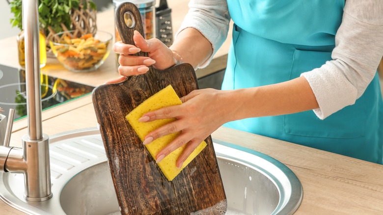 wooden cutting board being cleaned