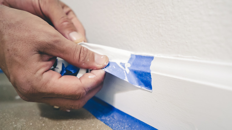 Person removing painter's tape