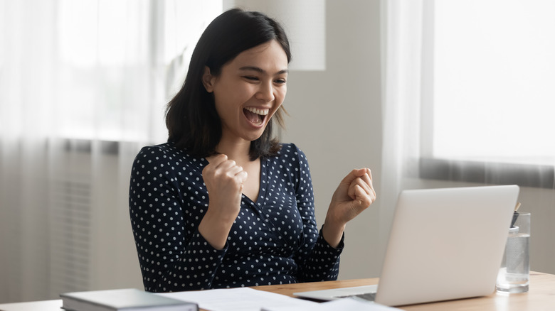 excited woman at desk