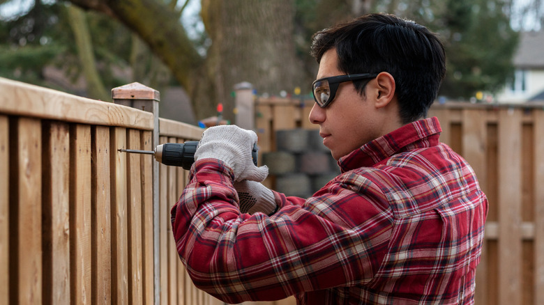 man repairing fence