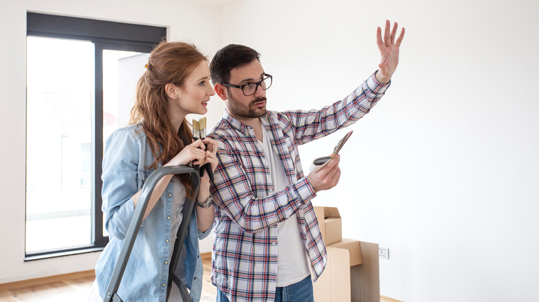 Couple planning how to paint white room