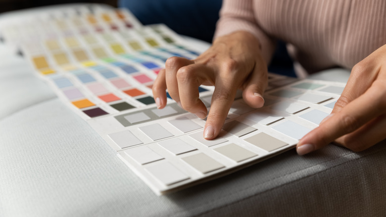 Woman looking at paint swatches, choosing paint color