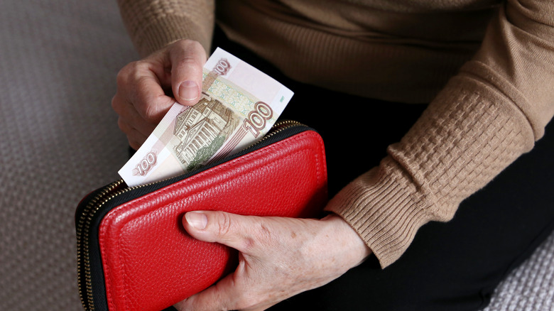 Woman taking money from wallet