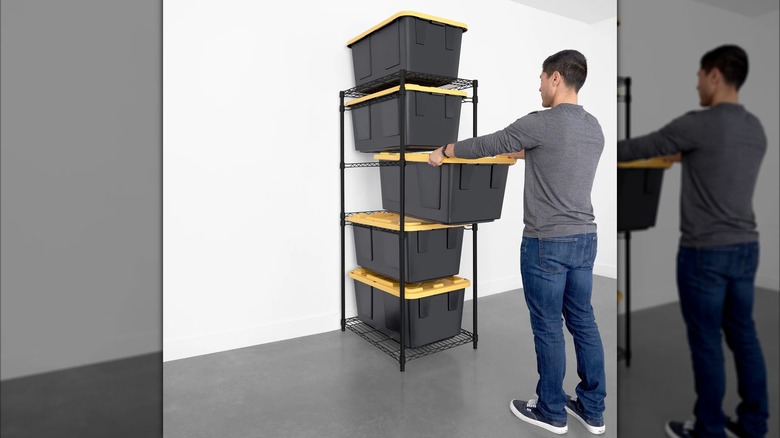 Man removing storage bin from rack