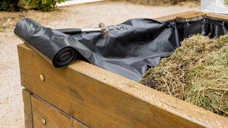 Plastic liner partially installed in raised bed